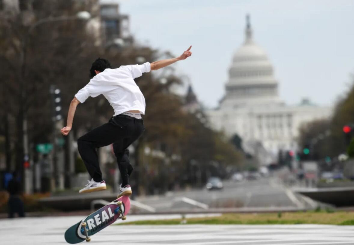 ▲3月27日,美国国会众议院通过2万亿美元财政刺激计划。图为美国华盛顿,一名男子在国会大厦附近玩滑板。 新华社记者刘杰摄